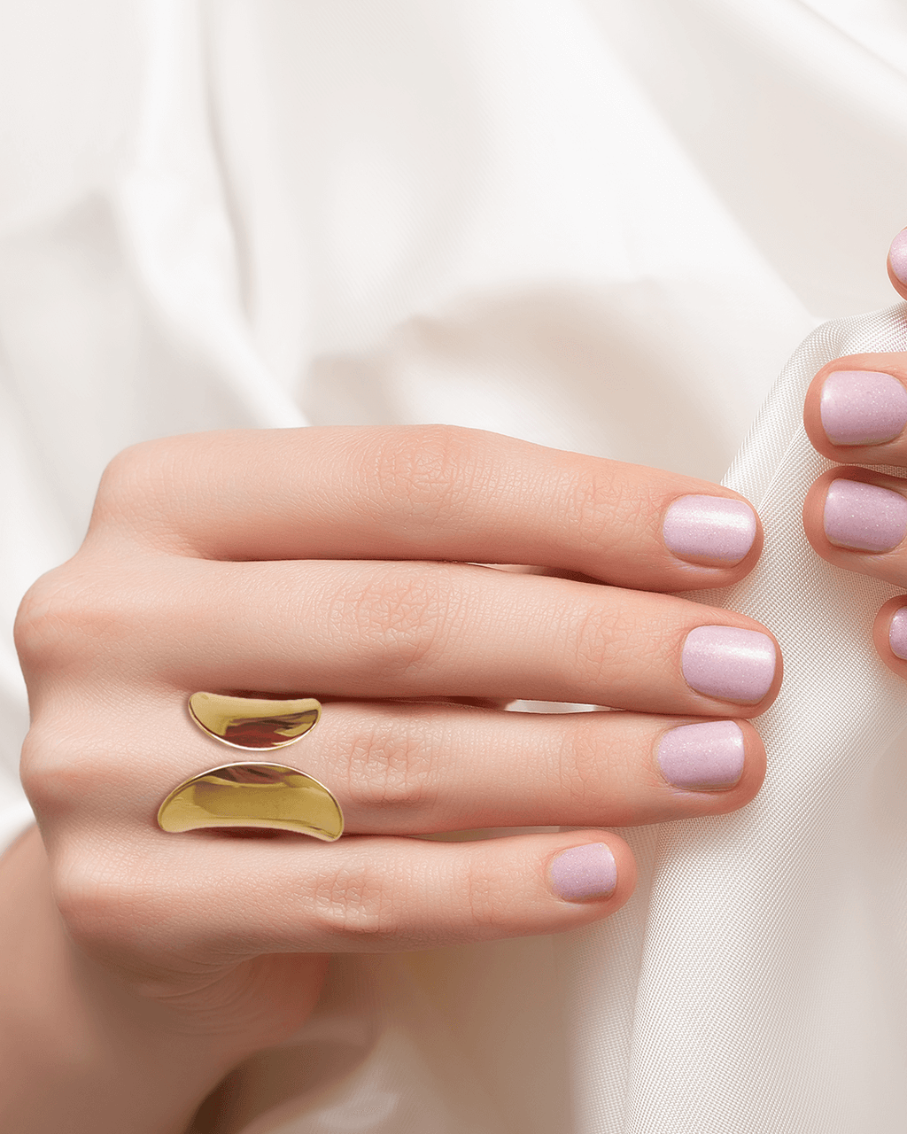 Femme portant une bague en acier inoxydable, élégance chic, sur une main avec des ongles roses.